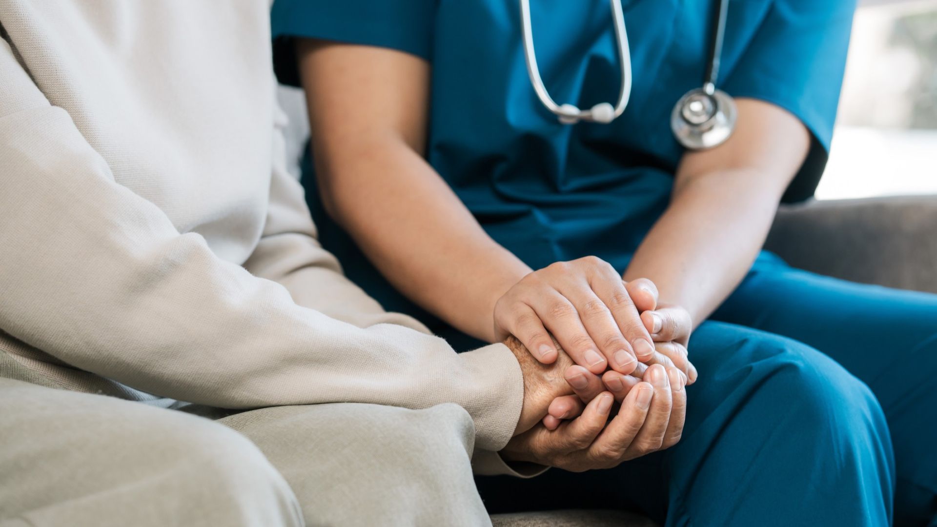 A nurse holding a patient's hand