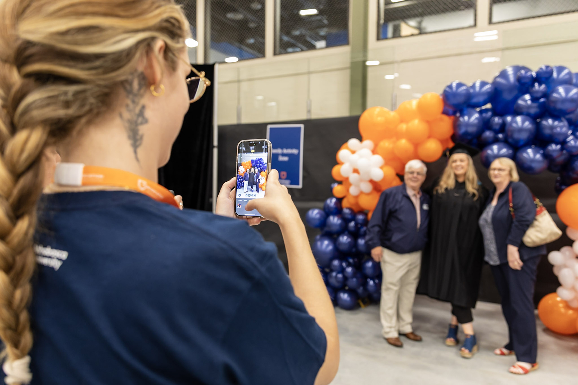person using a phone to take photos of a grad and family