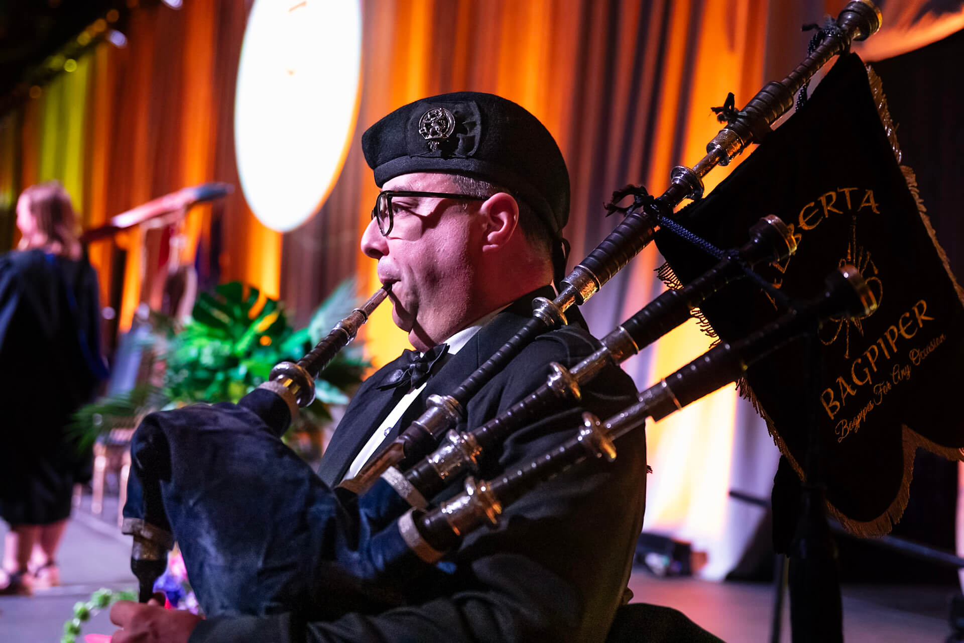 a bag pipe player leads the convocation procession