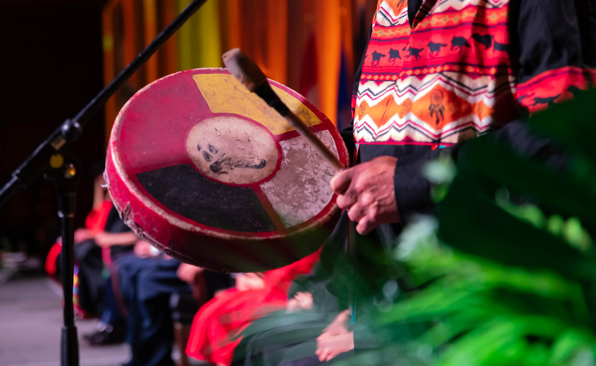 detail view of a person playing a traditional Indigenous drum