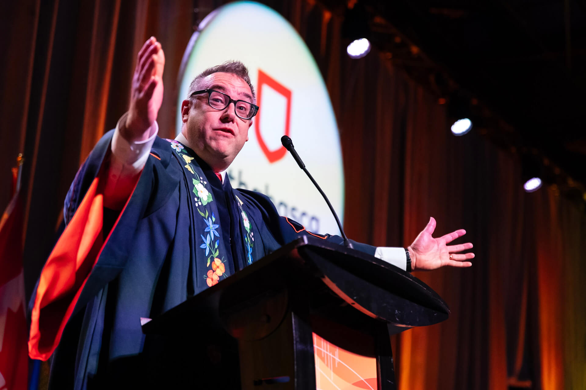 AU President Dr. Alex Clark with his arms wide welcoming grads and guests