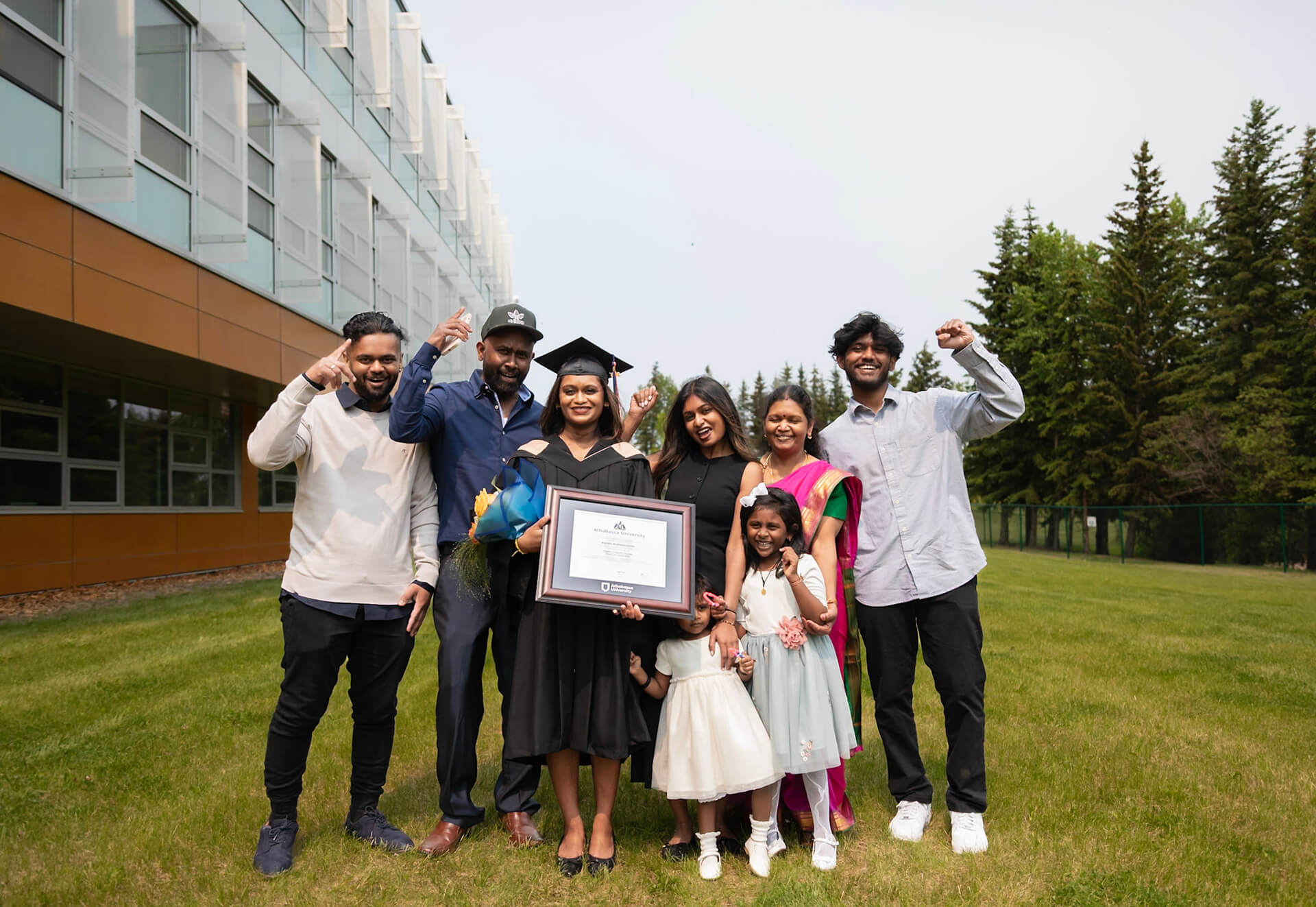 A grad and their family celebrates outdoors at AU campus