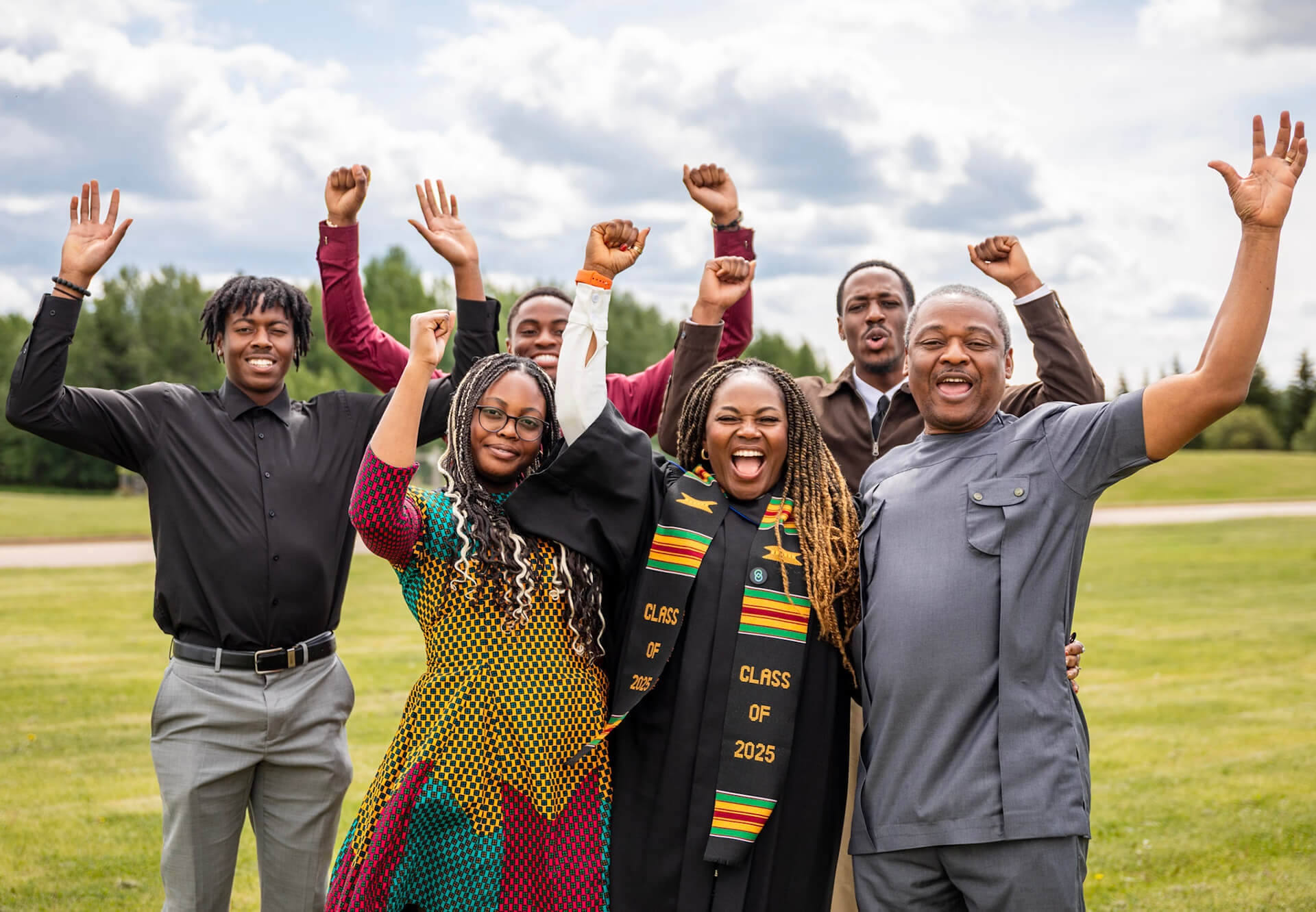 A grad celebrates with their family outdoors on AU campus