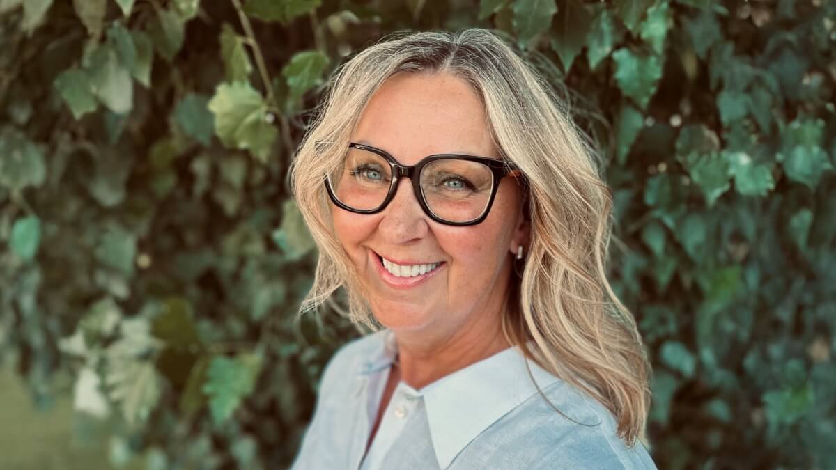 Cori Francis standing in front of green tree with lots of leaves