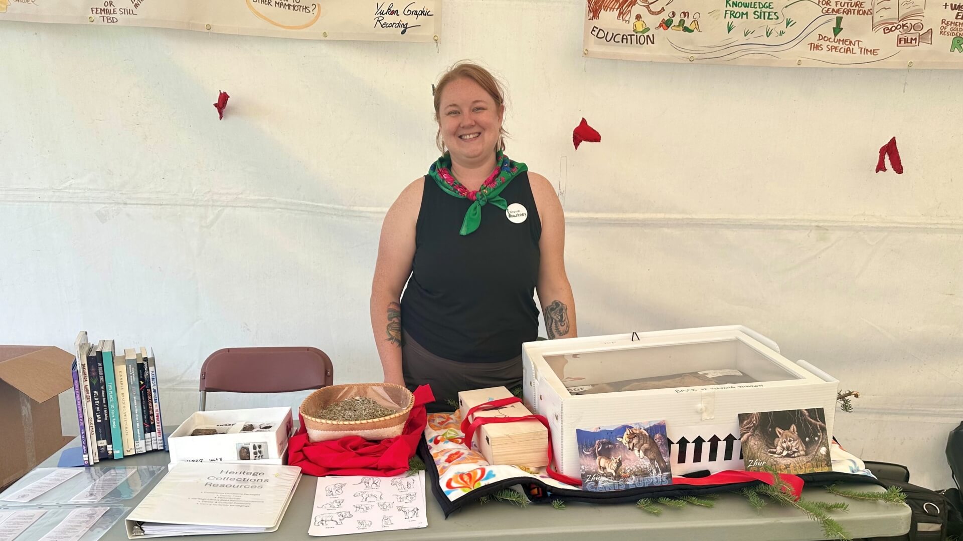 Courtney King standing behind a folding table with a variety of cultural belonging displayed on the table