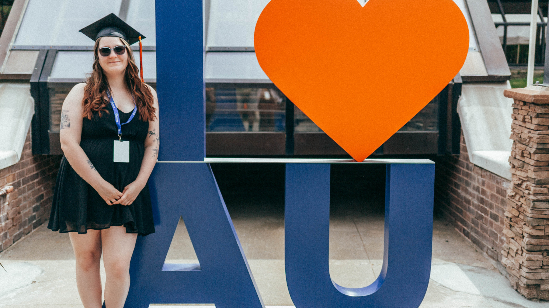 Grad in front of AU sign