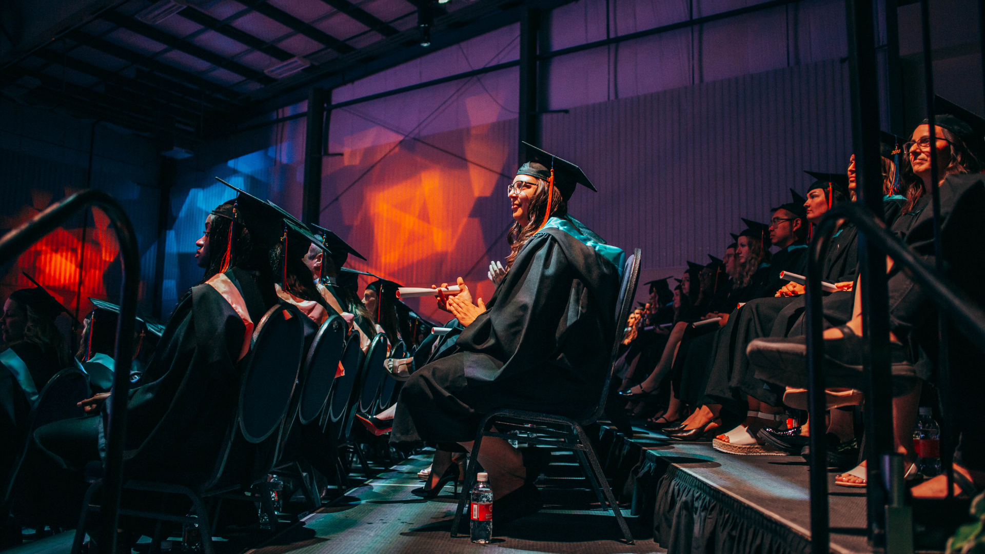 Grads sitting in chairs, waiting to graduate