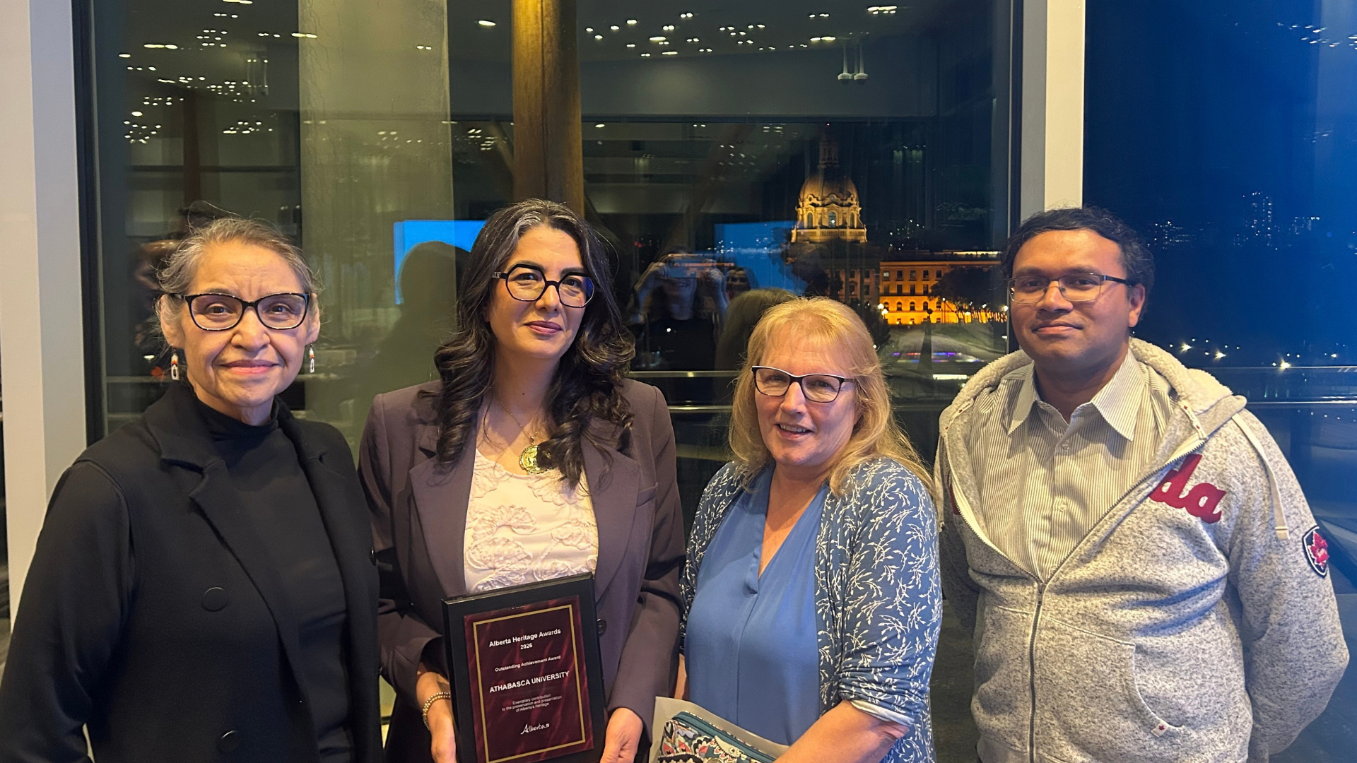 AU staff holding the Alberta Heritage Award for Outstanding Achievement