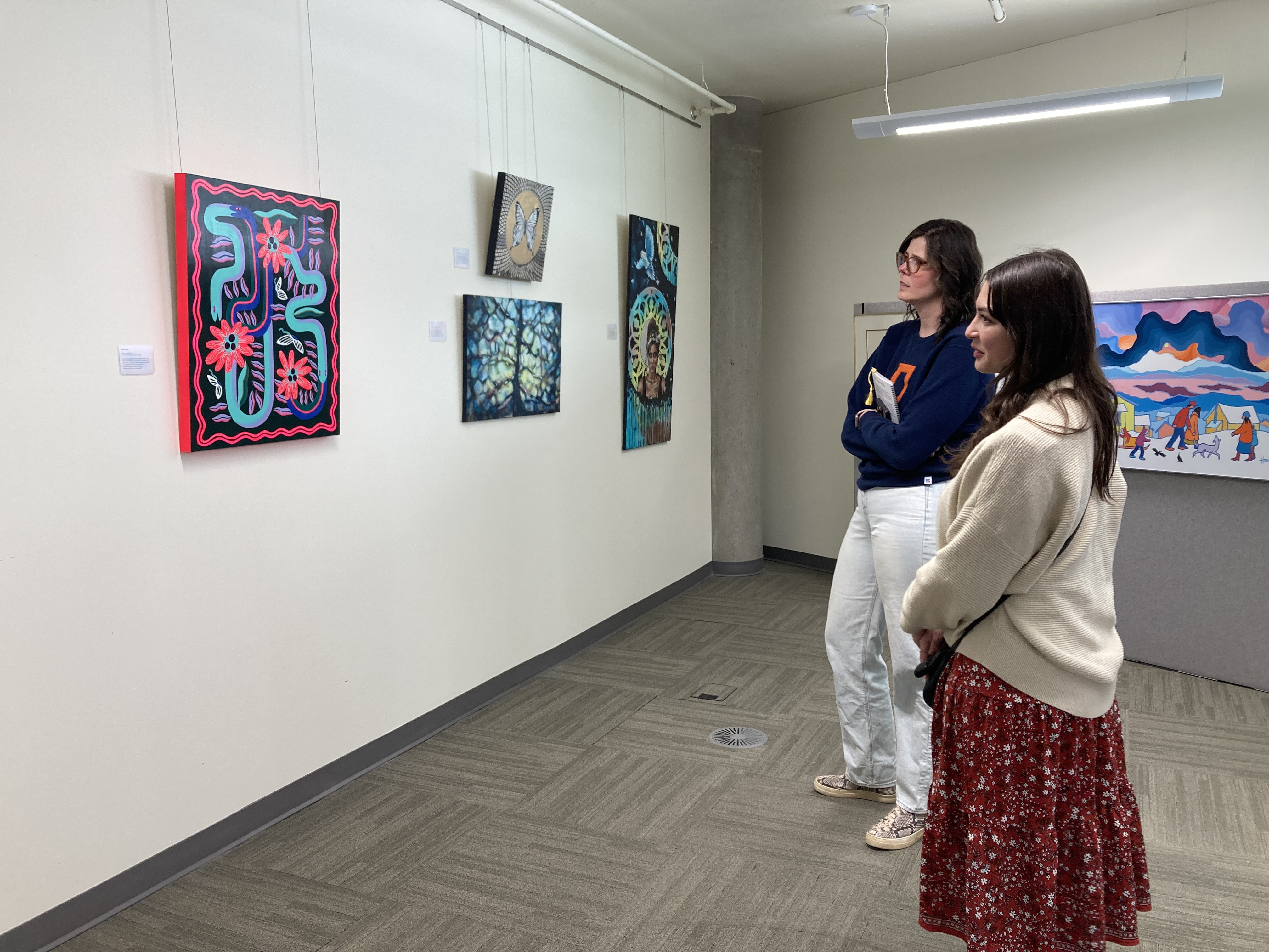 Event attendees looking at community-submitted art on the wall