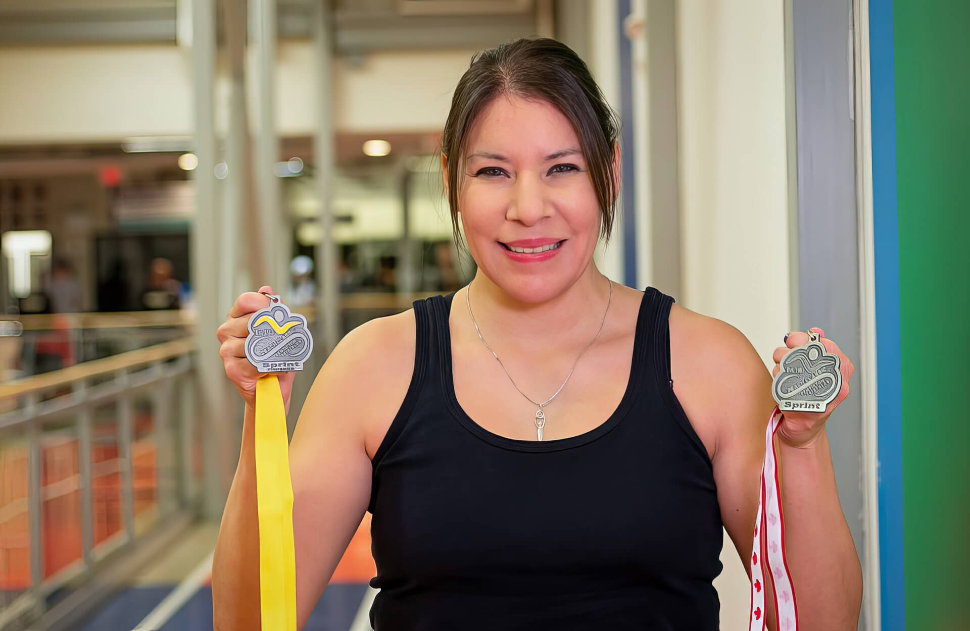 Kethra Stewart holding a pair of triathlon medals Kethra Stewart holding a pair of triathlon medals