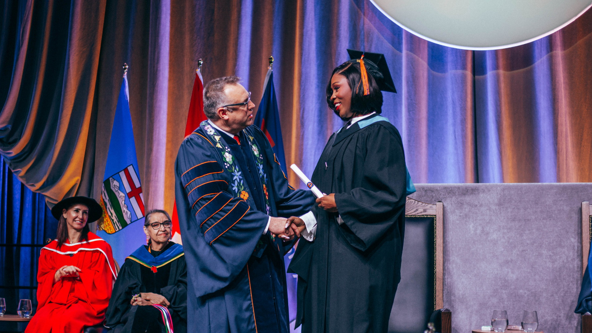 President Alex Clark shaking hands with grad