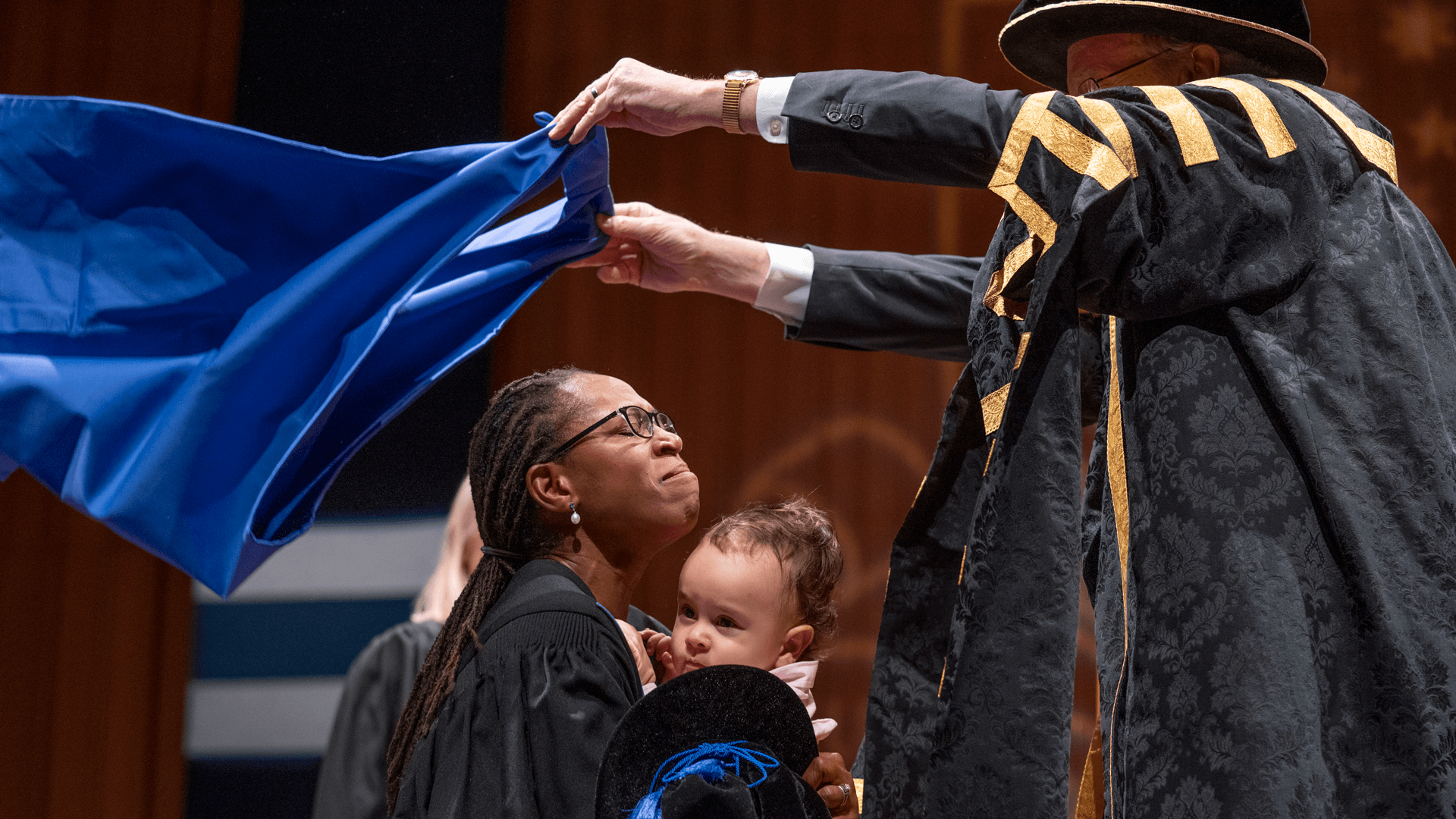 Dr. Veronica Fynn Bruey holds her son while receiving her doctorate at Australian National University.