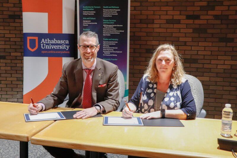 Athabasca University President Dr. Neil Fassina and Portage College President Nancy Broadbent signing a Memorandum of Action to strengthen the partnership between the two institutions.