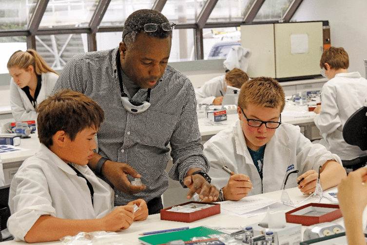 Dr. Ken Munyikwa of Athabasca University discussing rocks and minerals with school children in AU’s teaching laboratory in Athabasca. Photo: R.G. Holmberg.