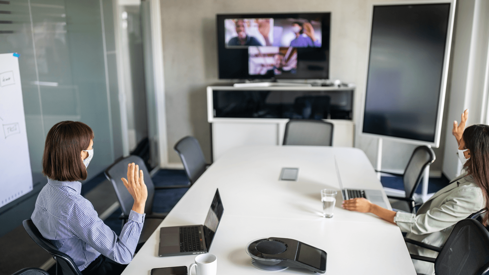 Hybrid virtual and in-person meeting in a boardroom and on TV