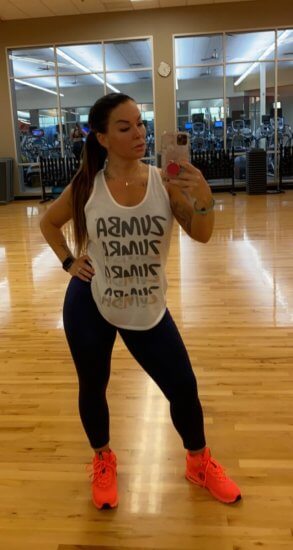Sheena Papin with a Zumba shirt in a gym studio