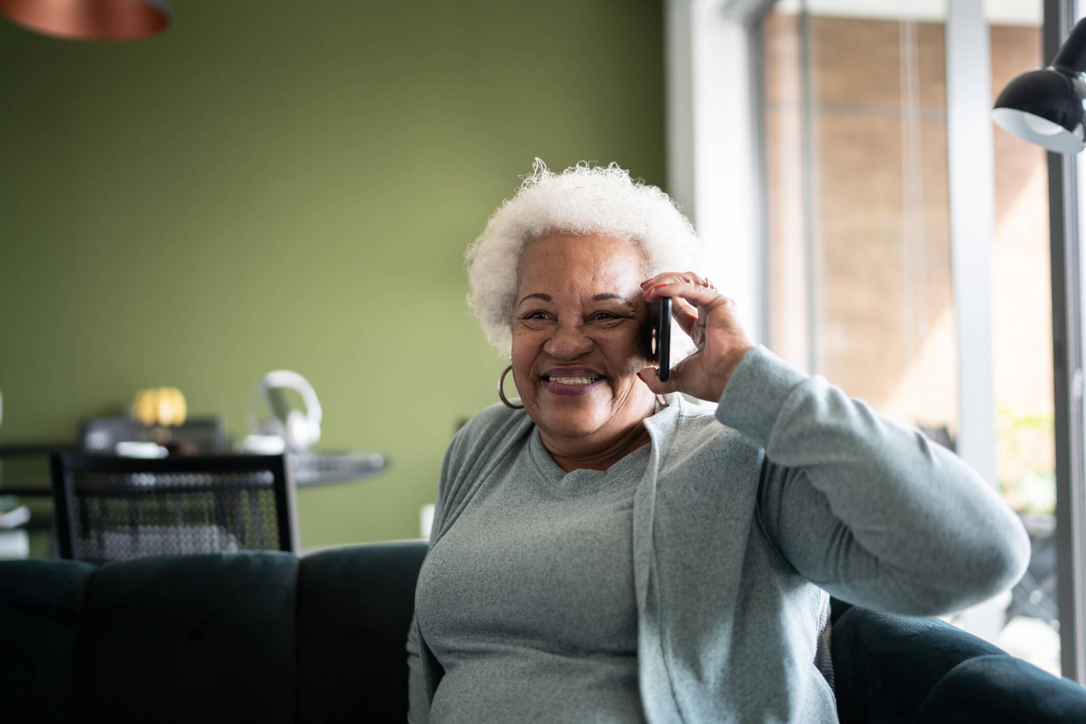 Senior woman talking on the phone at home
