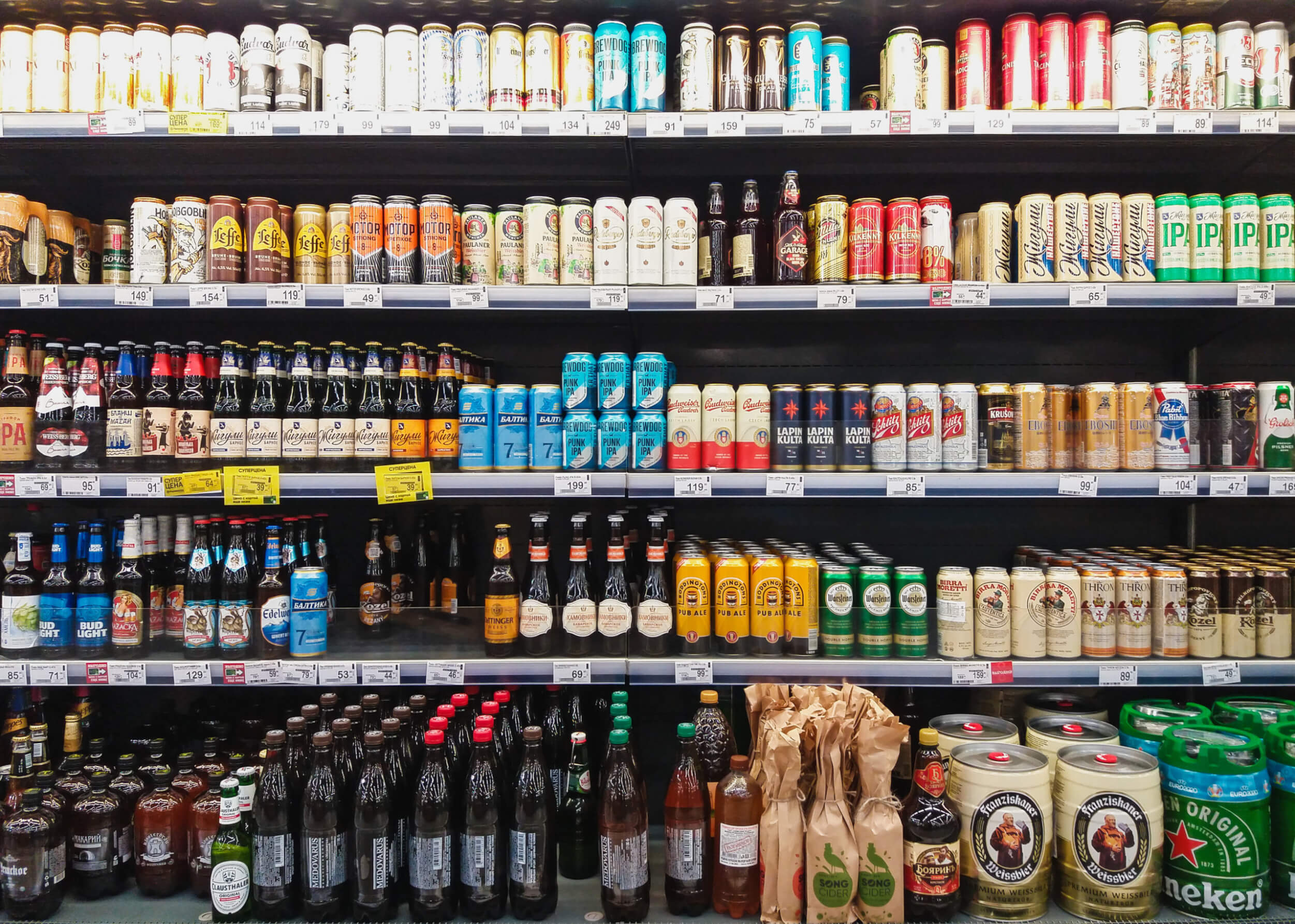 Beer in bottles and cans on grocery store shelves