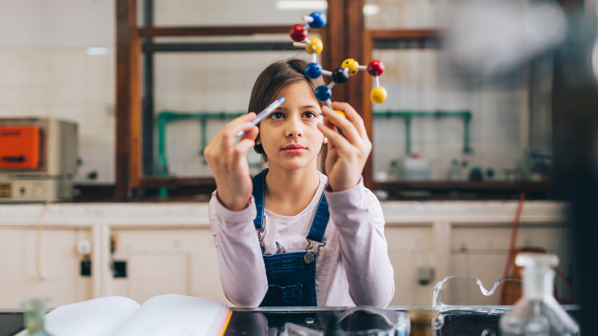 a young student holds a model of a molecule