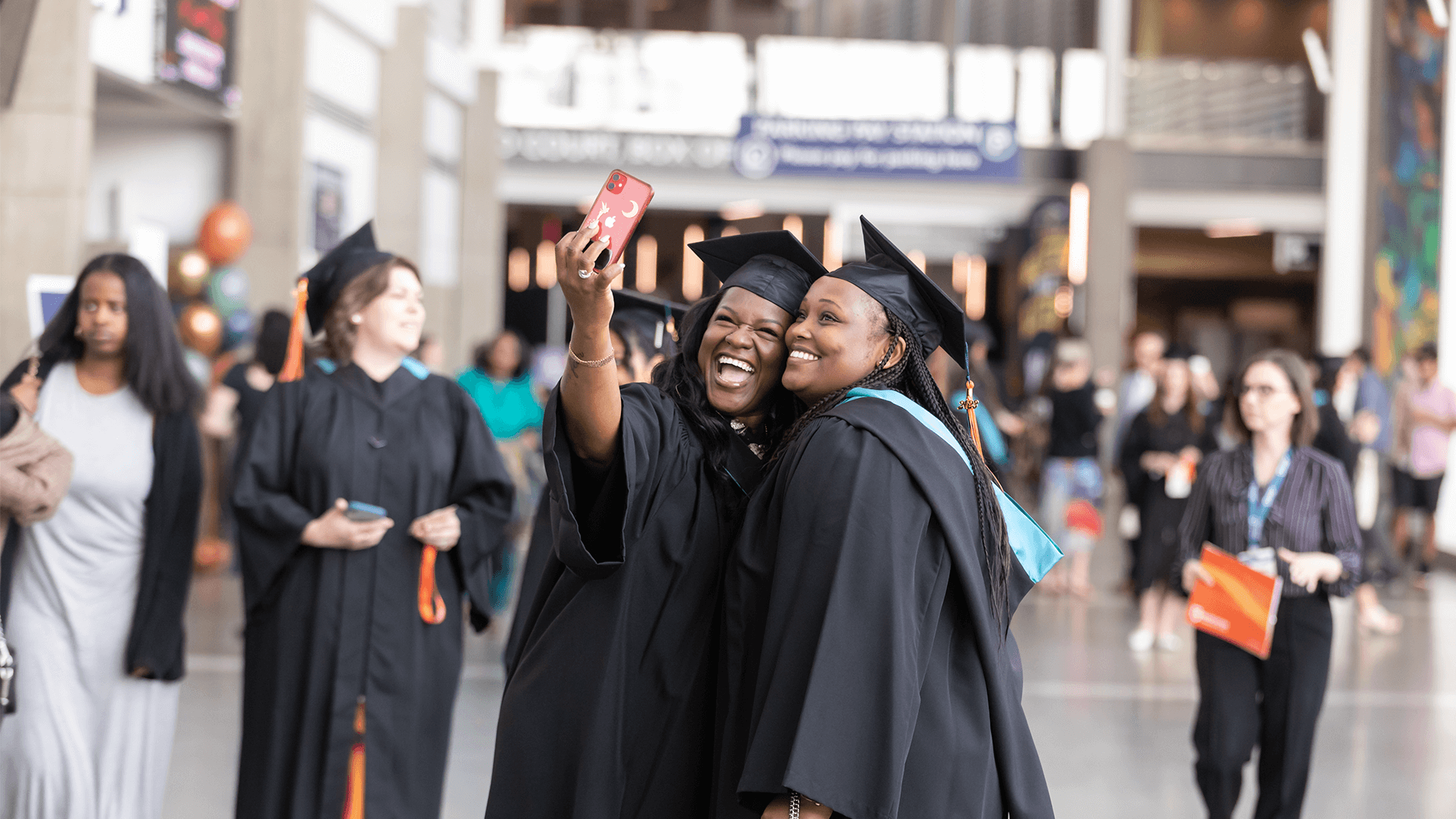 Two AU graduates taking a selfie and smiling
