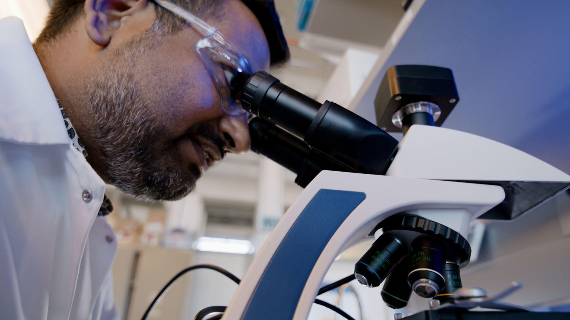 Dr. Srijak Bhatnagar looking into a microscope in his lab
