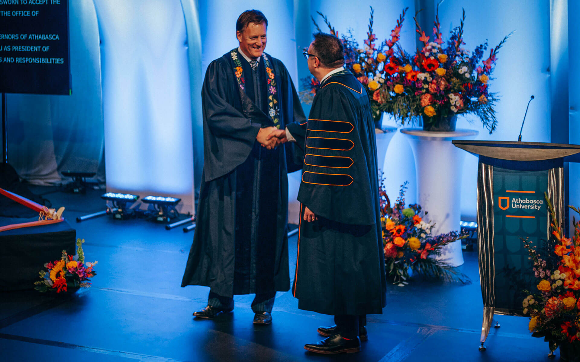 AU board chair shakes hands with Dr. Alex Clark