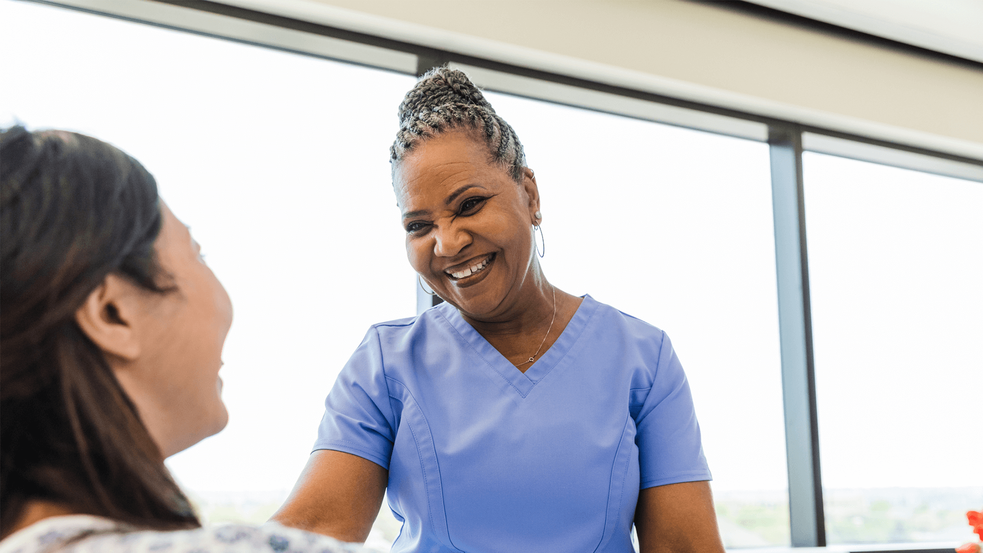 Nurse practitioner looks at patient with a smile