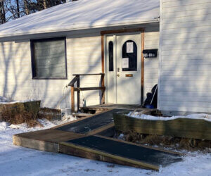 The outside of the shelter in the winter - a white building with a ramp going up to the door