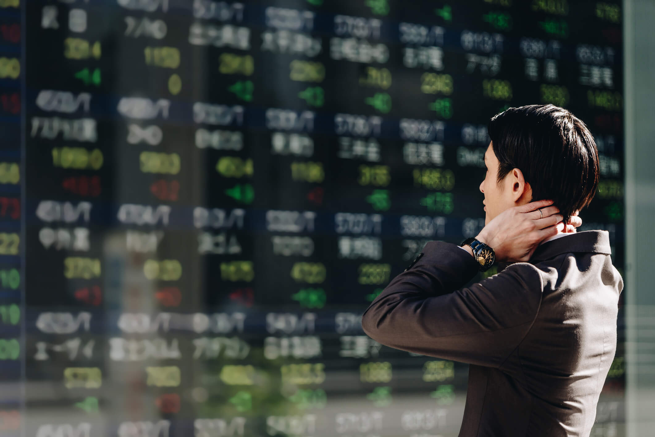 A man looking at stock prices on a large board