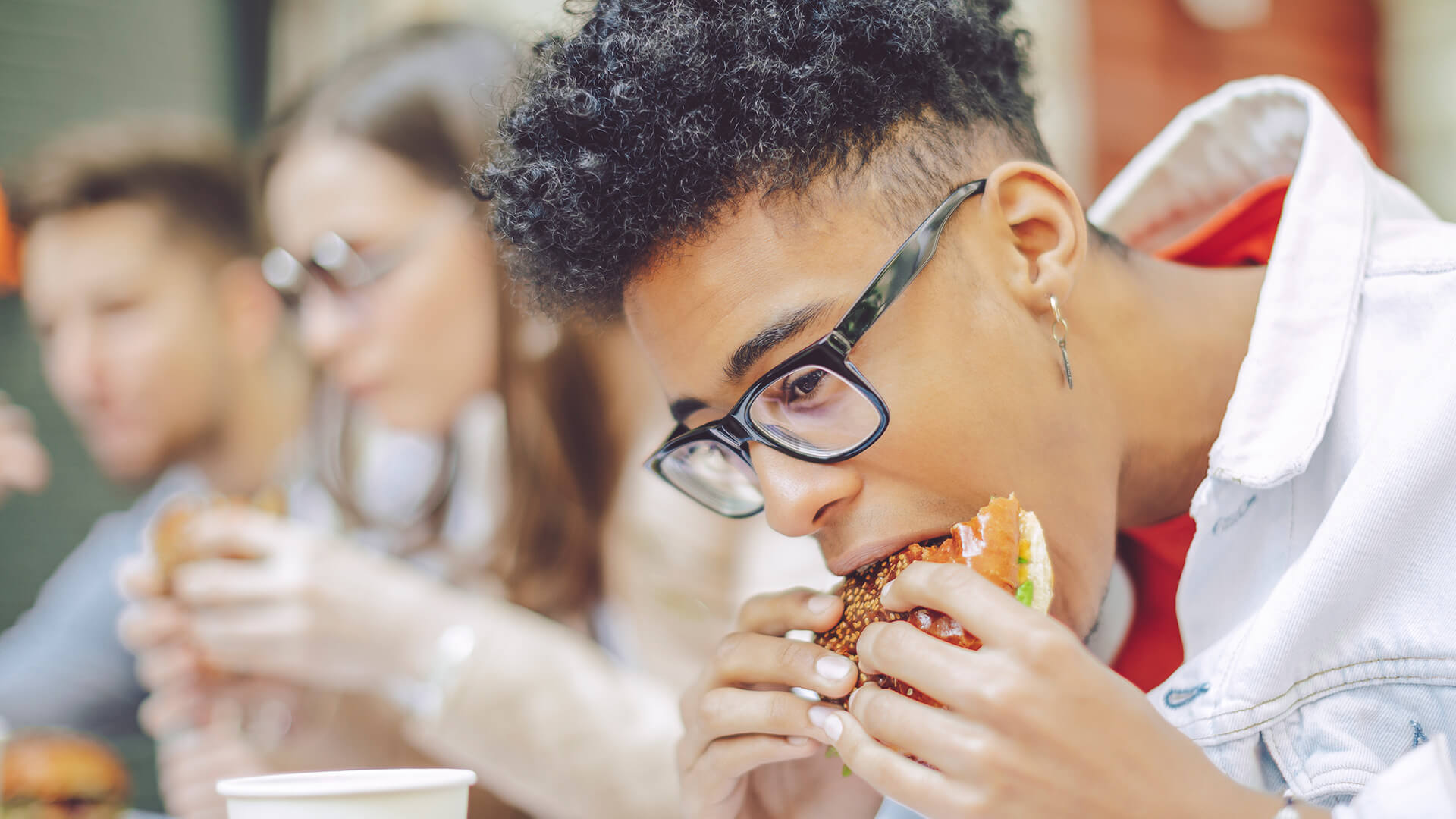 teen eating a hamburger at lunchtime
