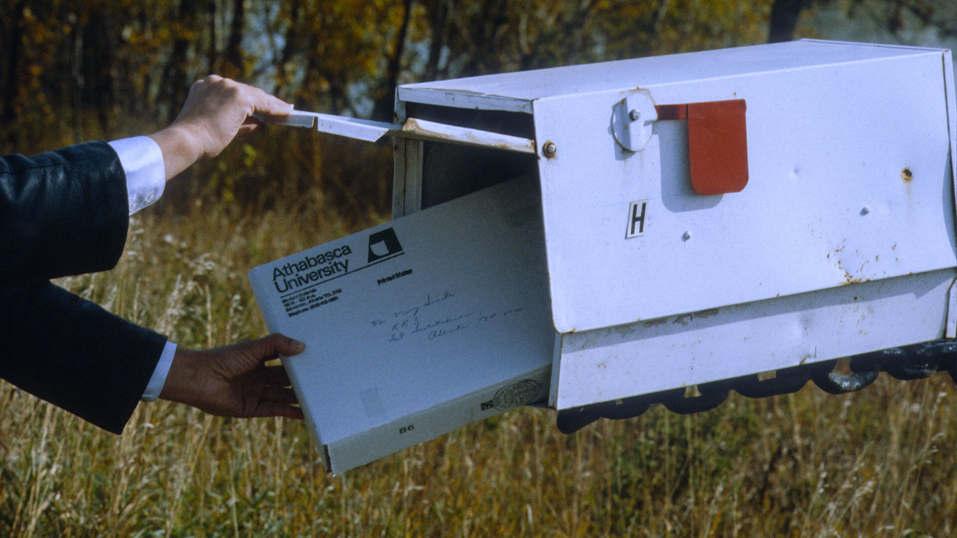 mailbox-1991.056.15439 a hand removing a package from a mailbox
