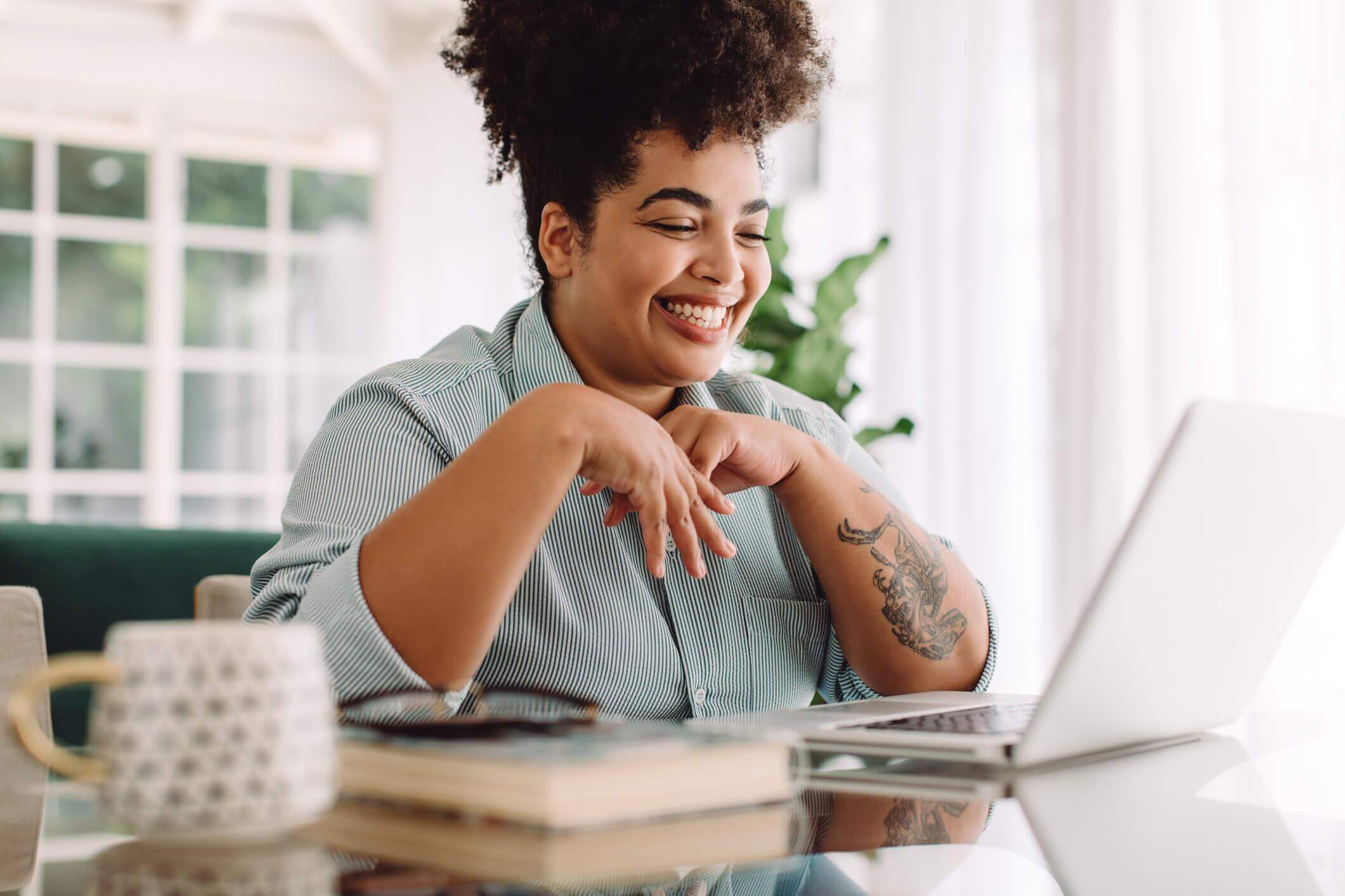 Positive woman video calling using laptop at home person presenting on a computer