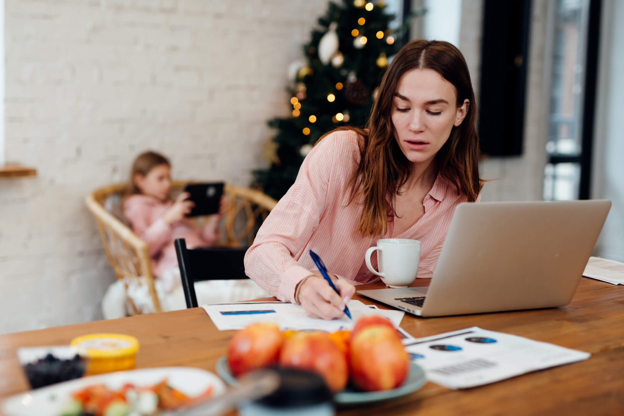Young woman works at home while her daughter stays home on winter vacation Christmas holiday stress Athabasca University