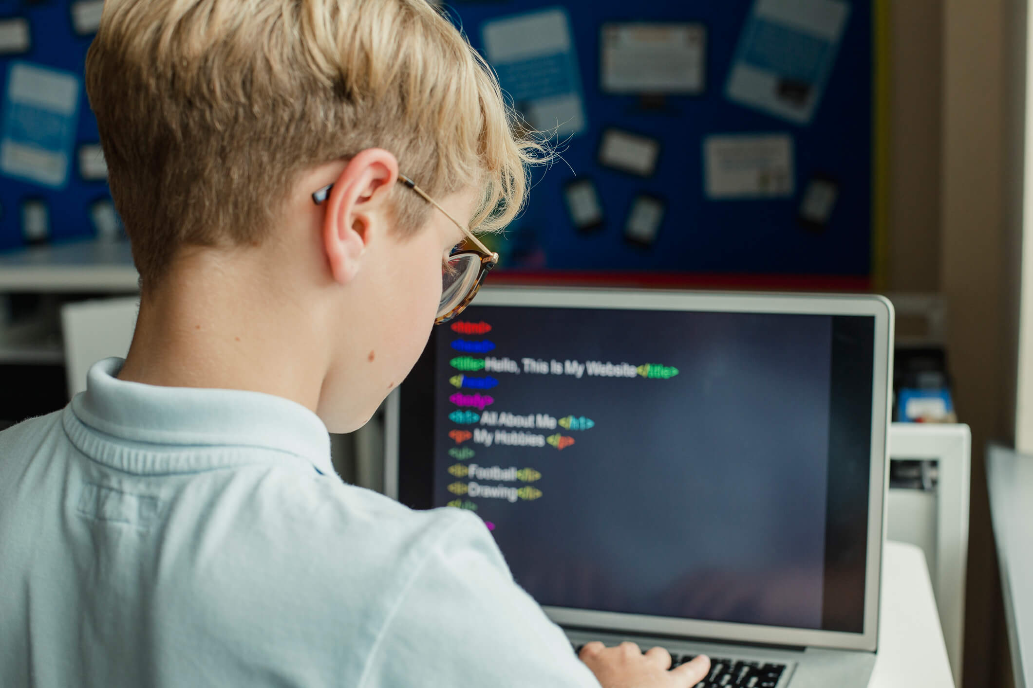 Male Student Learning Coding In School student learning to code on a computer