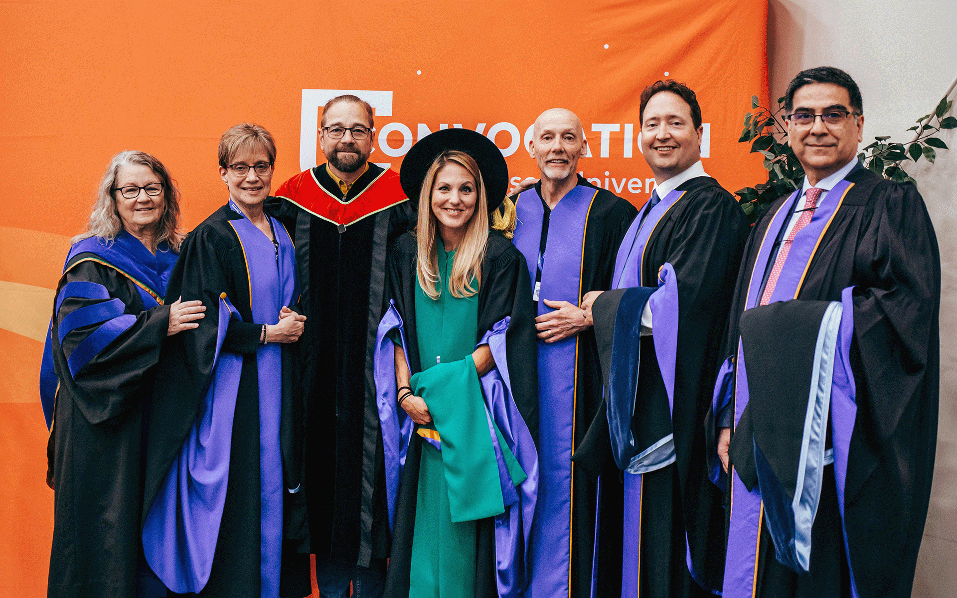 DBA Group of people dressed in academic regalia smiling at the camera