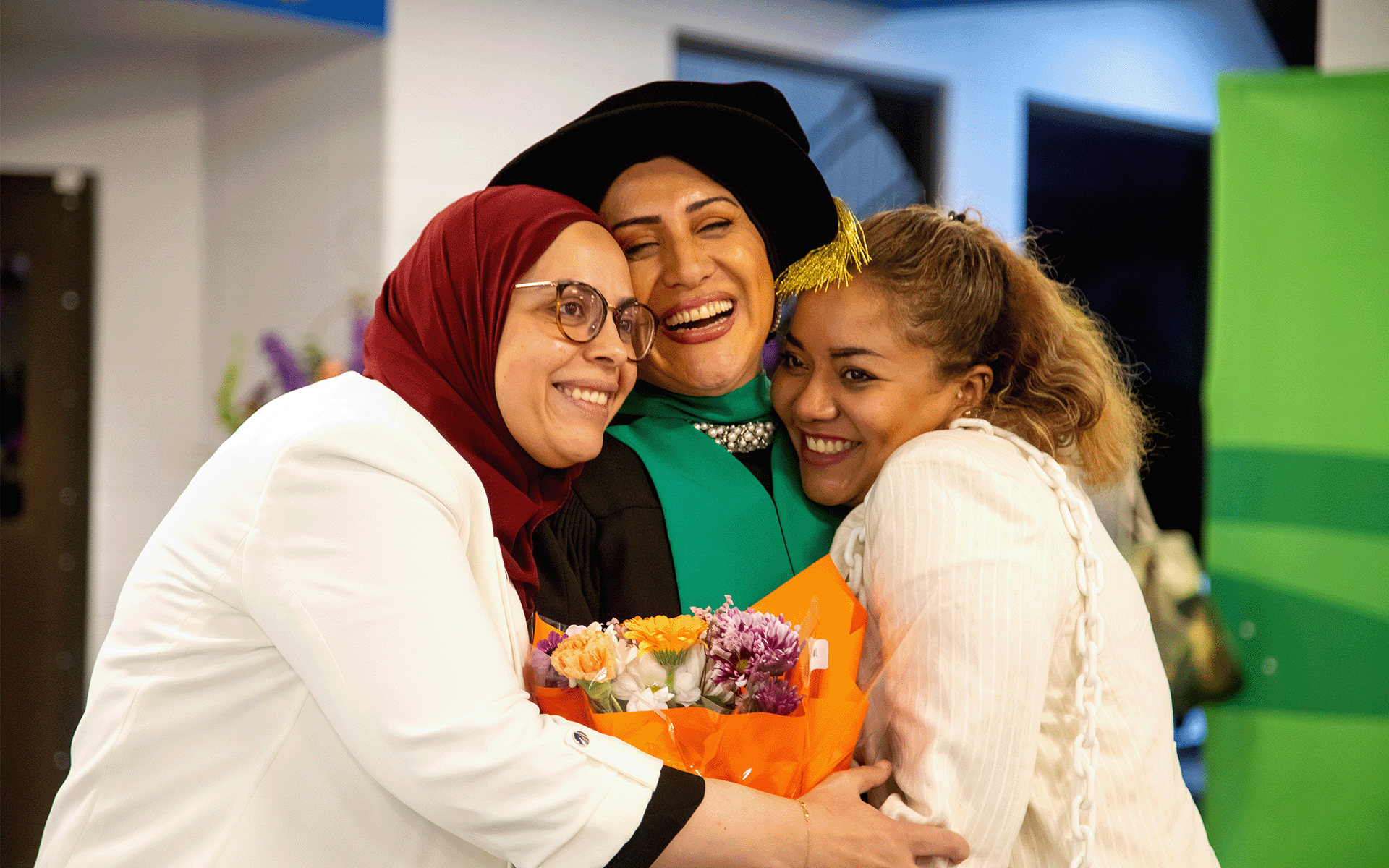 Group of 3 smiling A trio of woman hugging and smiling.