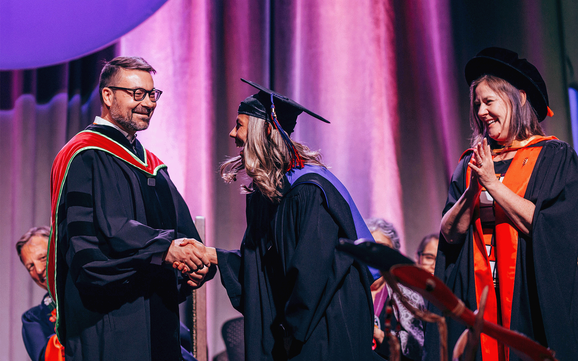 MBA grad Graduate shaking hands with a dean during the convocation ceremony