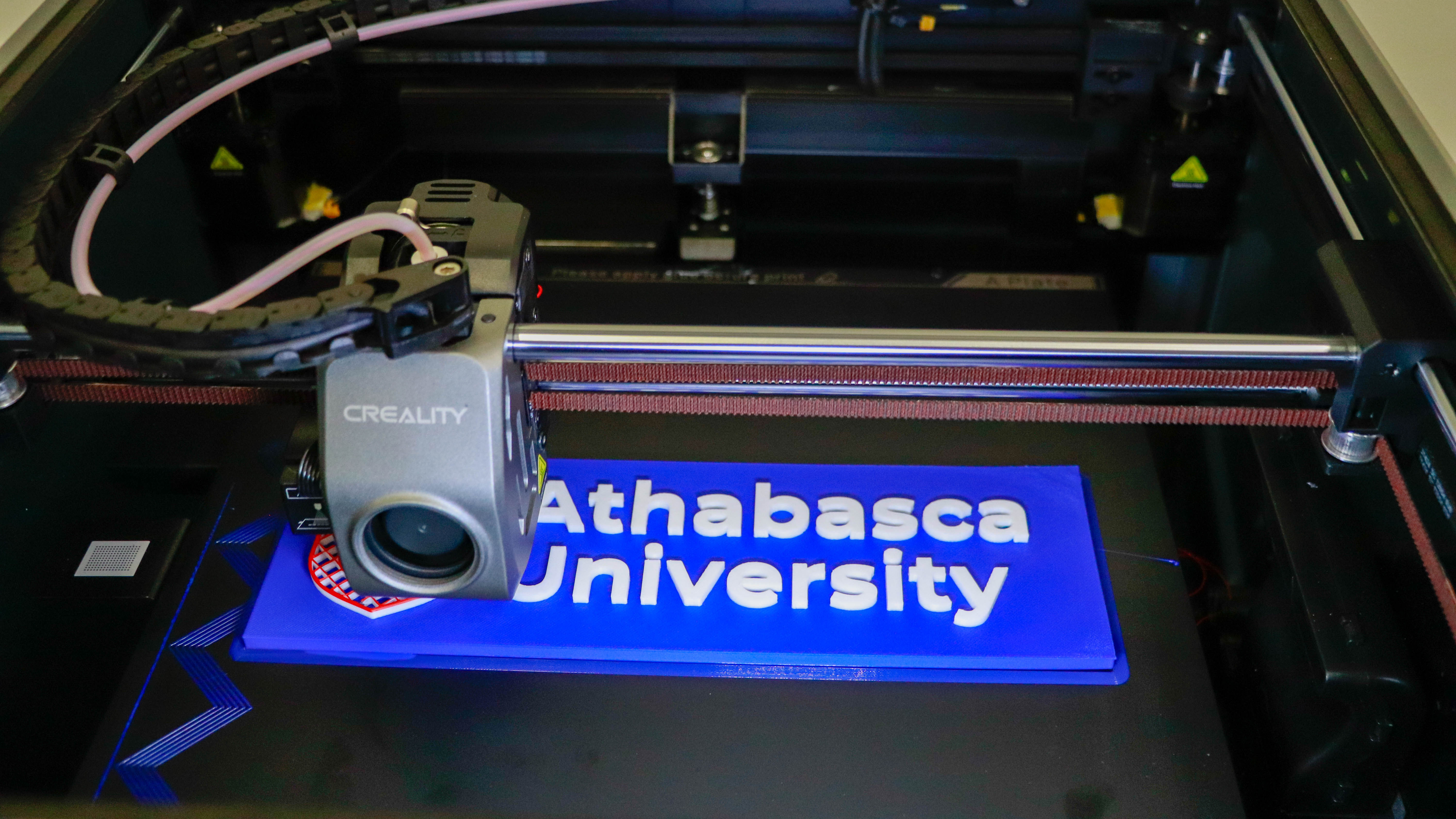 The 3D printer at the Athabasca Architectural Maker Space printing out an Athabasca University logo