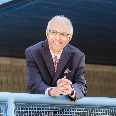 Esmail Bharwani leaning on a blue metal railing